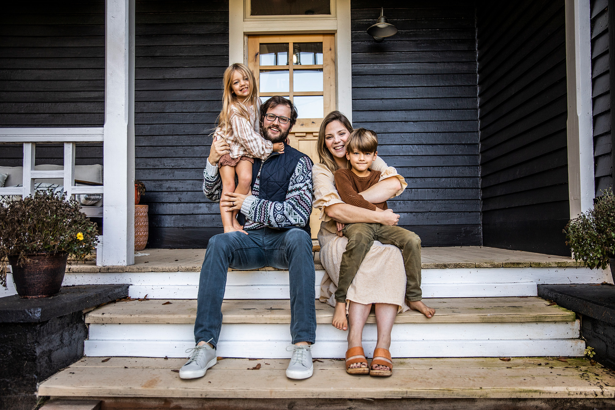 family of four sitting on porch